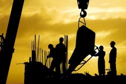 Workers buliding a structure with eqipment on a crane